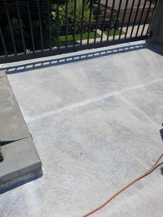 Fiberglass matting also known as an anti-fracture membrane is applied as part of the waterproofing system used by American Decking & Waterproofing for a patio project in Los Angeles.