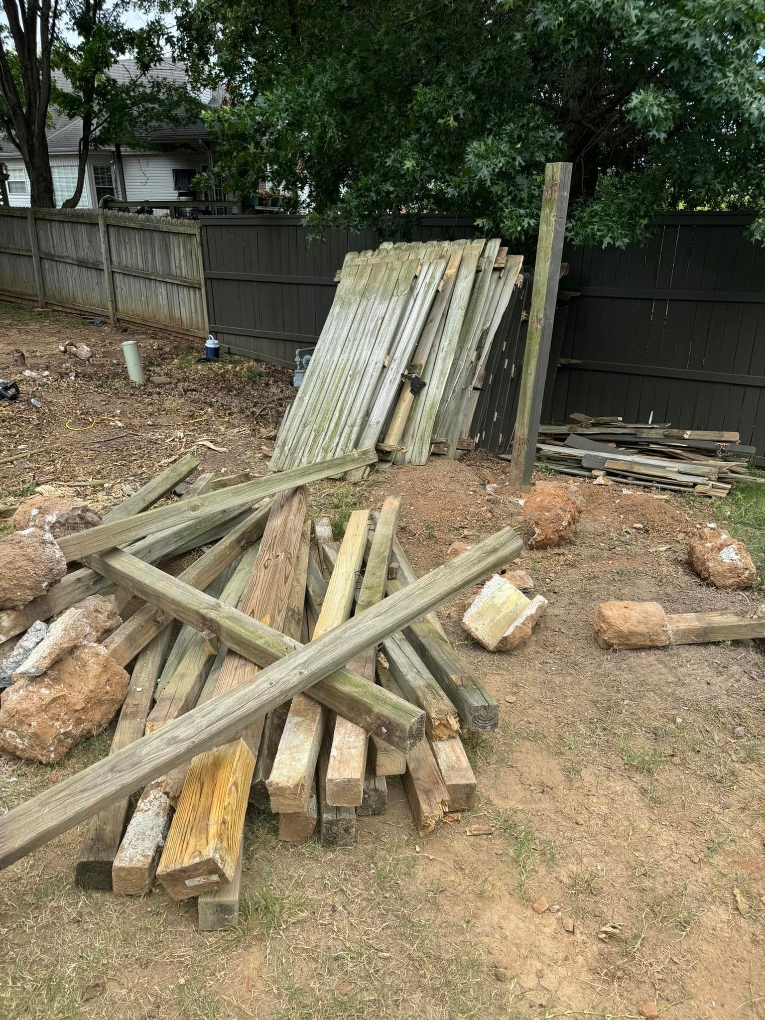 Woman in straw hat smiles, holding wine glass near a lake.