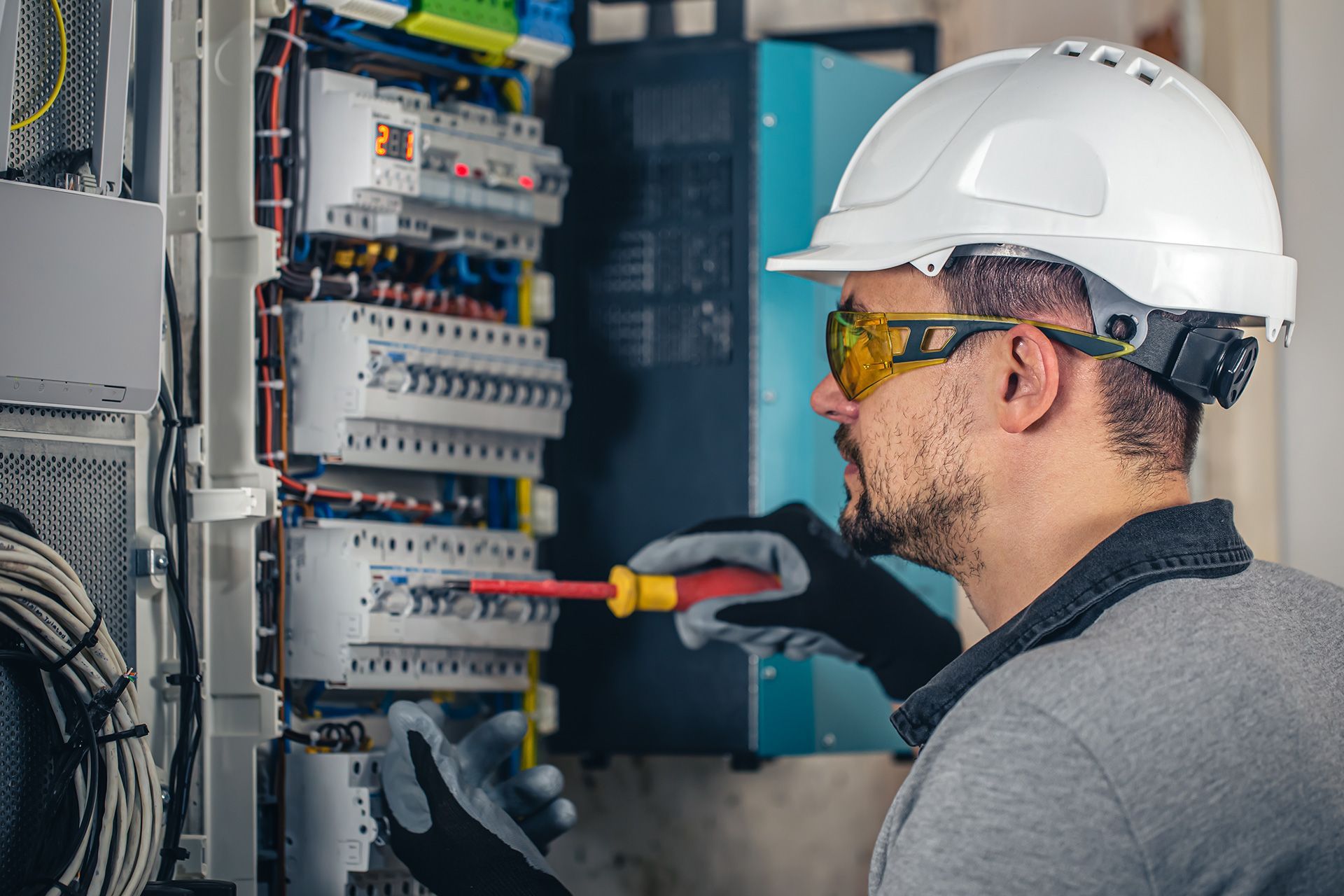 Electrician repairing electrical wiring inside a home panel