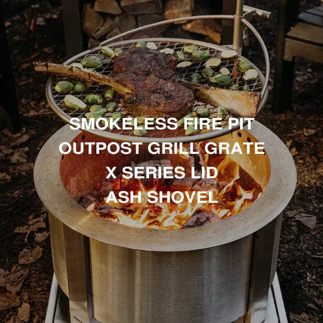 Smokeless fire pit with cooking grate, grill, lid, and ash shovel; flames visible inside.