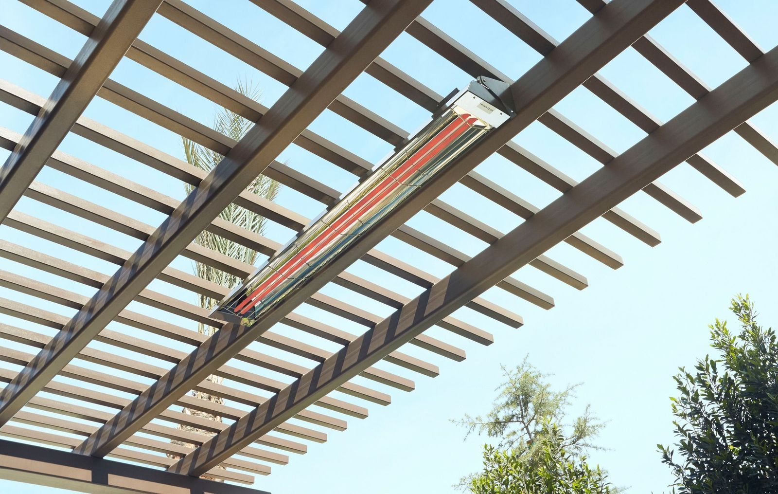 Two light-colored Adirondack chairs with a shared table sit on a lush lawn near a metal armillary sphere garden ornament.