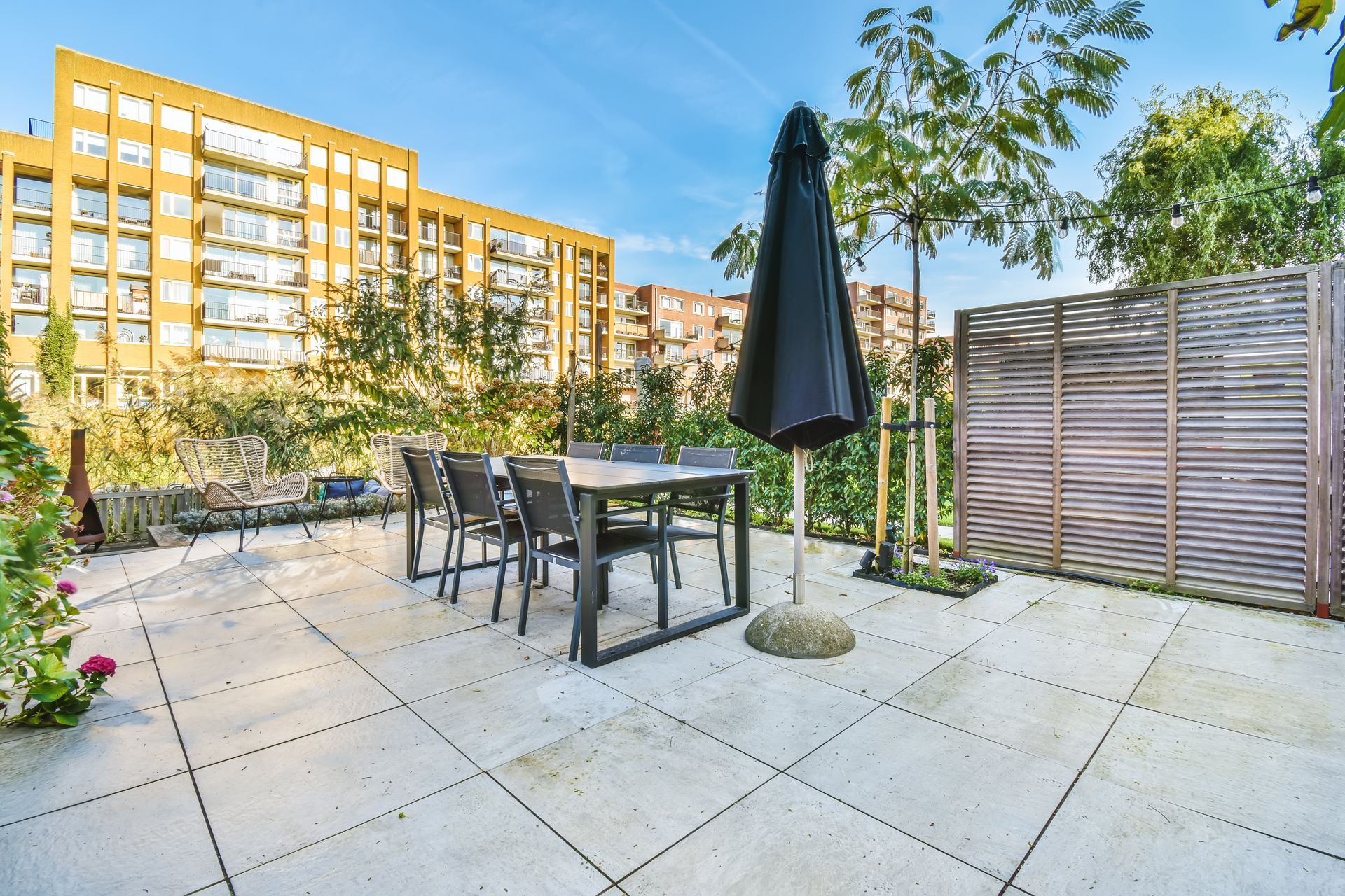 A smiling person with dark hair, wearing a red cable-knit sweater against a neutral, paneled wall background.