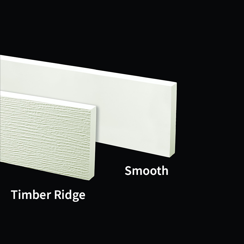 A piece of white, smooth-finish trim partially overlapping a piece of white, wood-grain textured trim.