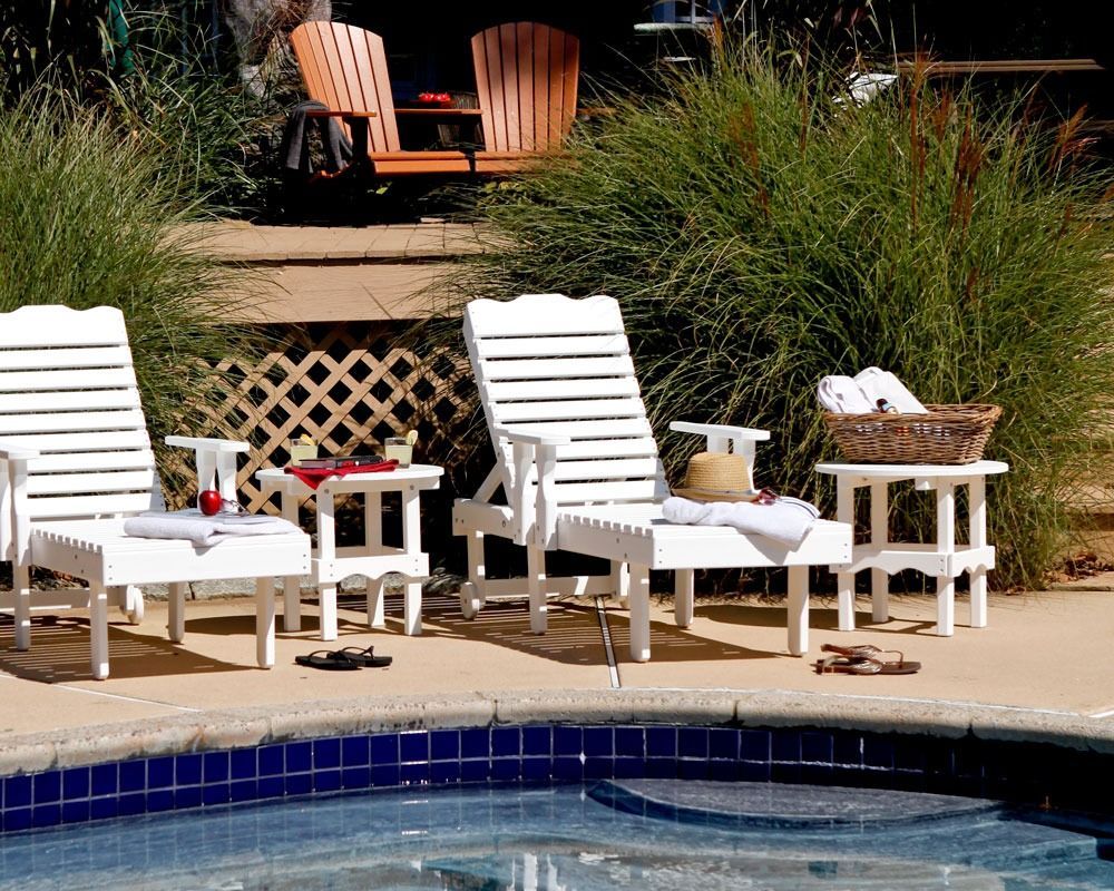 A smiling person with dark hair, wearing a red cable-knit sweater against a neutral, paneled wall background.
