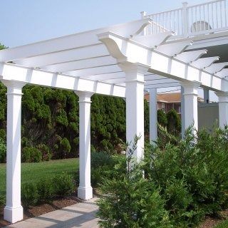 Two light-colored Adirondack chairs with a shared table sit on a lush lawn near a metal armillary sphere garden ornament.