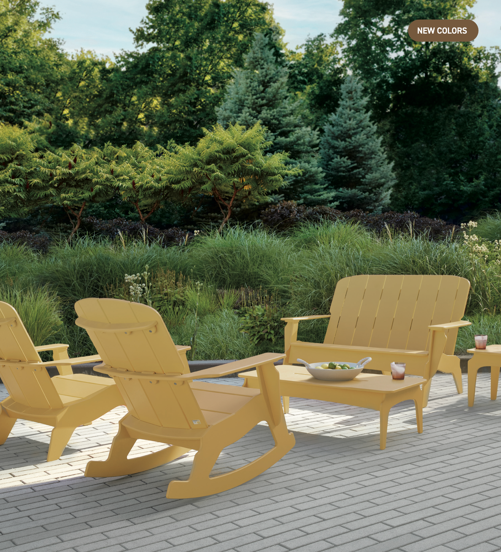 Yellow patio furniture, including a love seat, two rocking chairs, and a coffee table, on a paved outdoor patio.