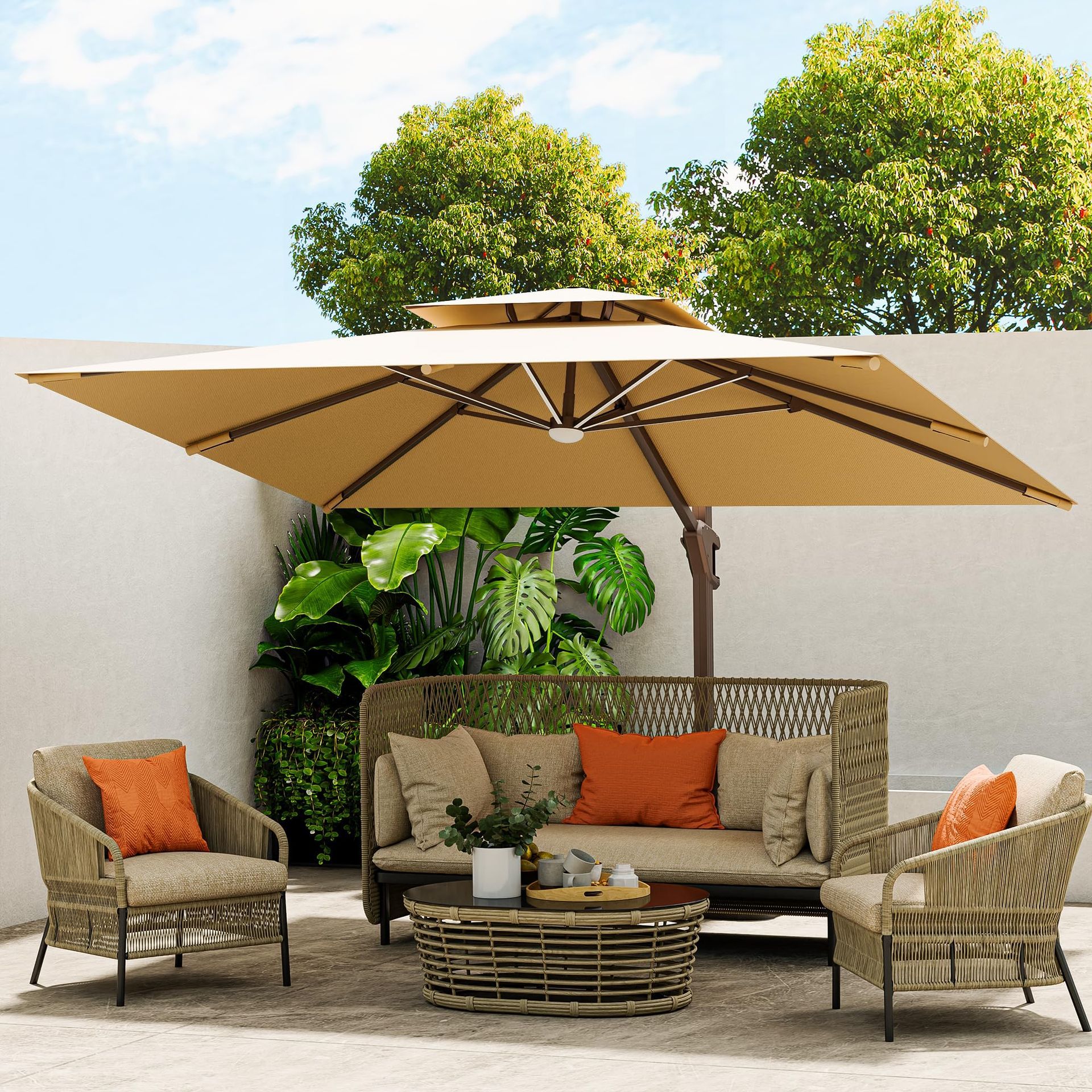 An outdoor lounge set with a beige umbrella, two chairs, and a sofa with orange cushions on a patio by a white wall.