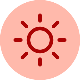 A red circular icon featuring a central circle surrounded by eight short, evenly spaced radiating lines, representing a sun.