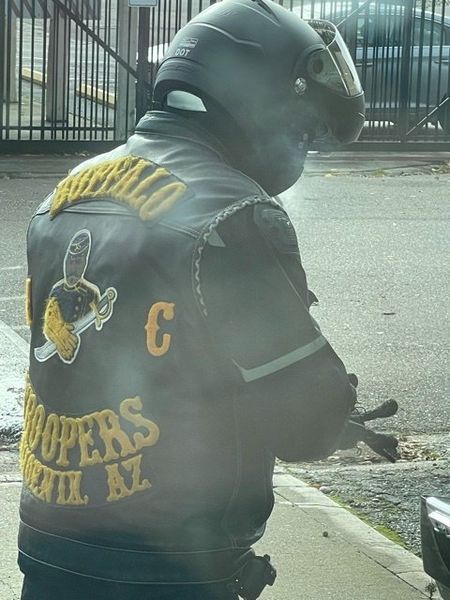 Motorcyclist wearing a black leather vest with 