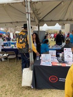 Man in leather jacket stands by table with 