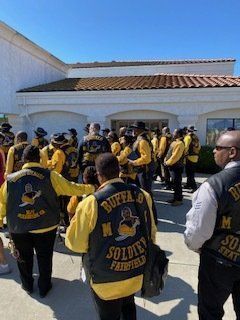 Group of people wearing yellow and black vests with 