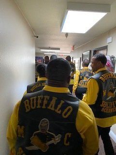 Men in yellow shirts and black vests with 