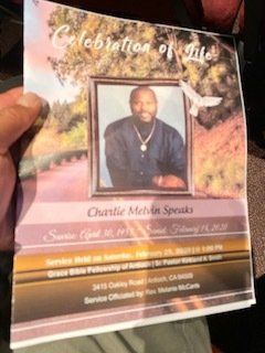 Memorial service program with a portrait of Charlie Melvin Speaks.  The program is held by a hand.