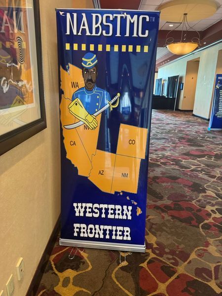NABSTMC Western Frontier banner with map and soldier illustration. Blue and gold colors in an indoor setting.