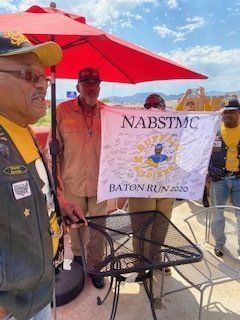 Group of men holding a banner for a motorcycle club's Baton Run 2020. They are outdoors.