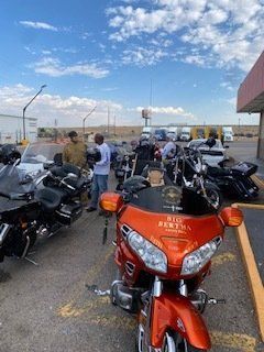 Motorcycles parked, bikers gathering. Orange bike 