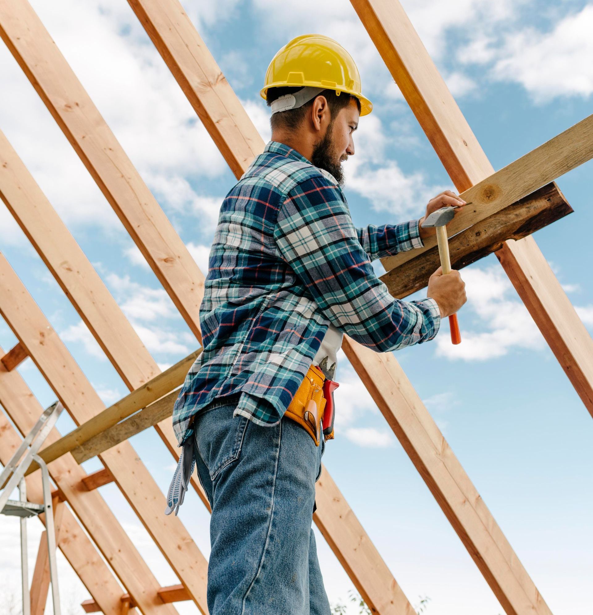 a man wearing a hard hat is working on a wooden structure .