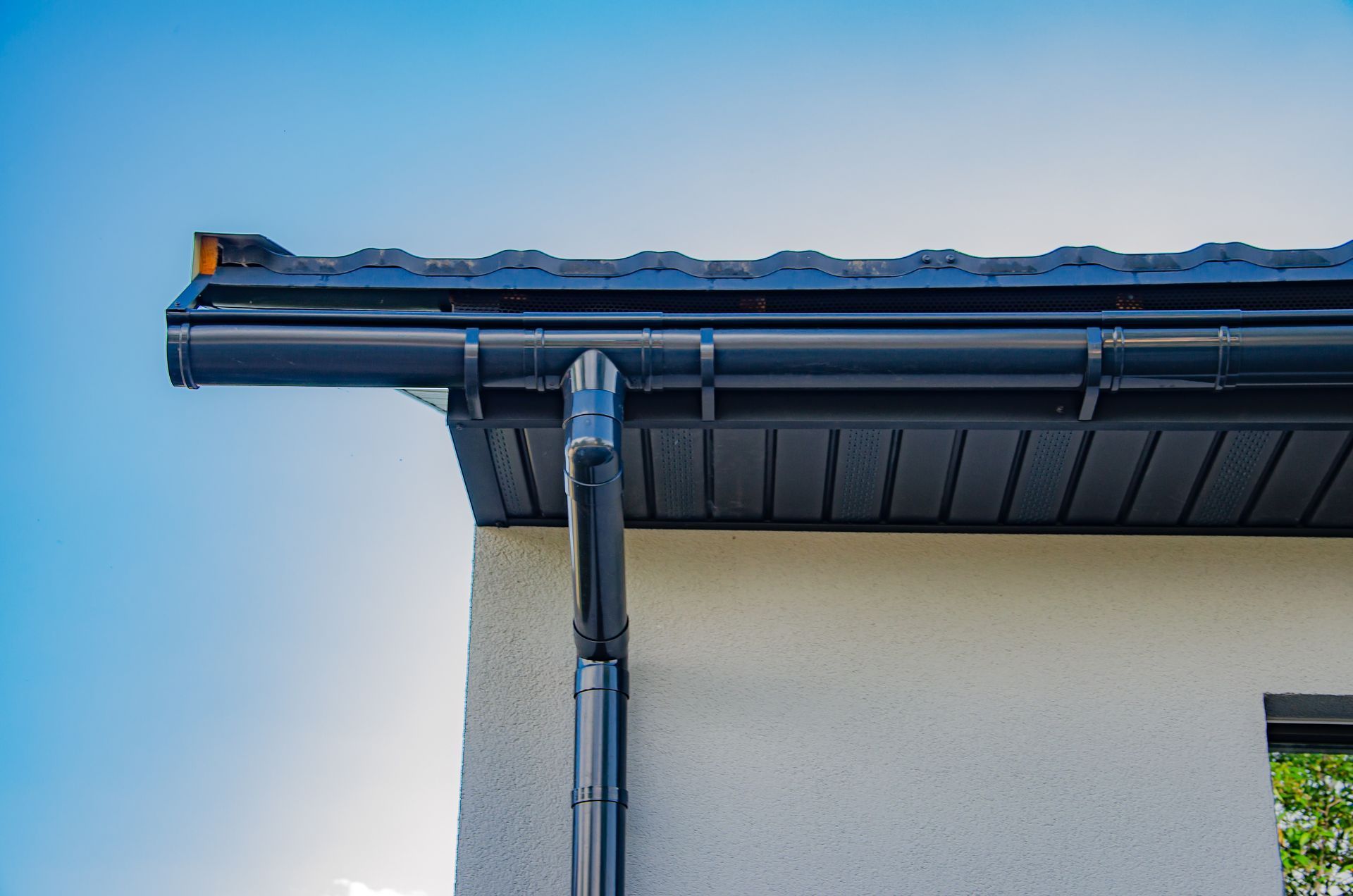 a close up of a black gutter on the side of a house .