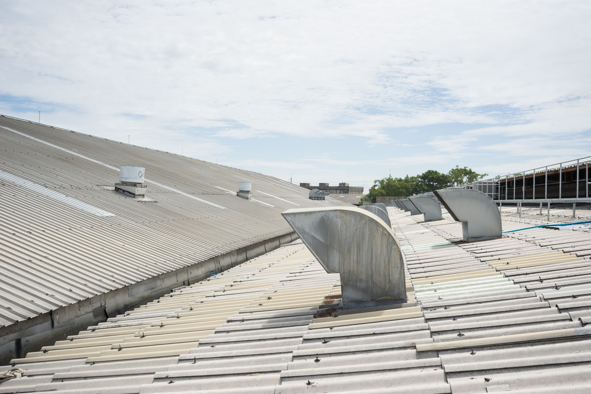 the roof of a commercial building with a ventilation pipe on it 