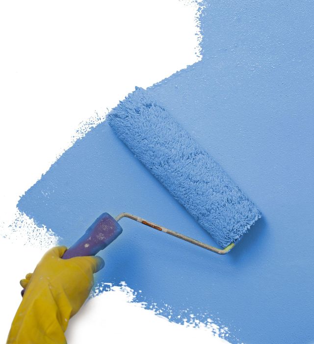 a person is painting a wall with a blue paint roller