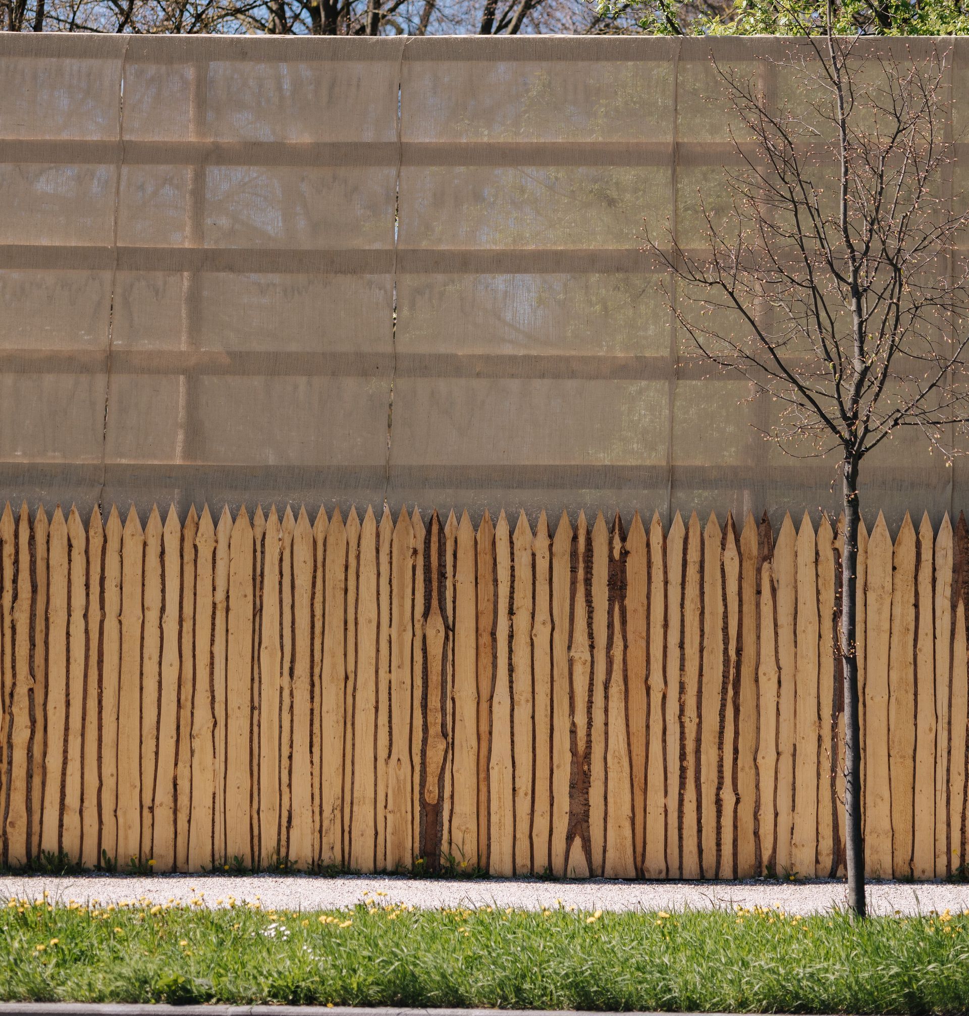 a wooden fence is surrounded by trees on the side of the road .