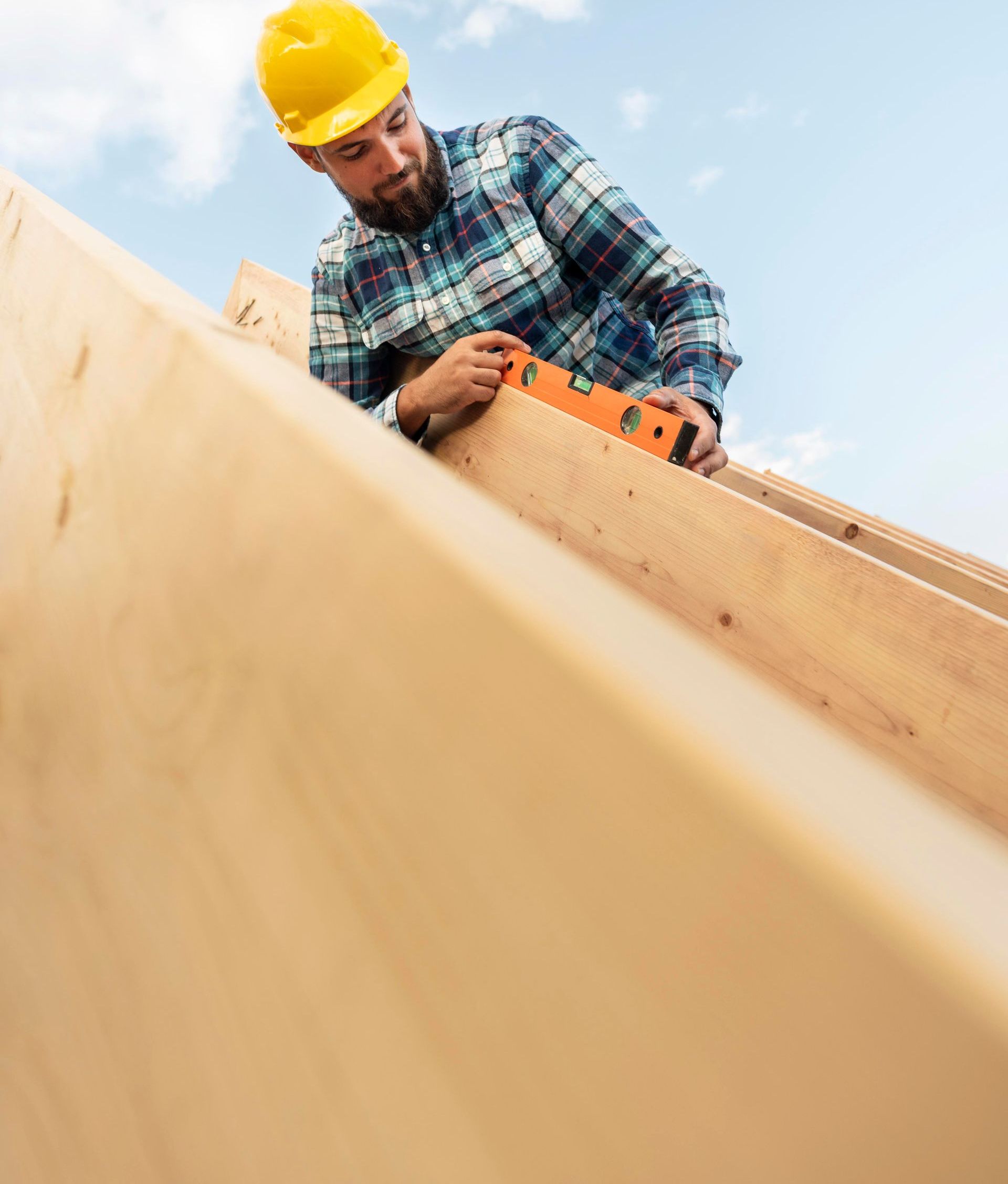 a man wearing a hard hat is working on a piece of wood .