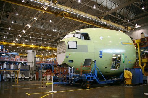 A large airplane is being built in a factory.