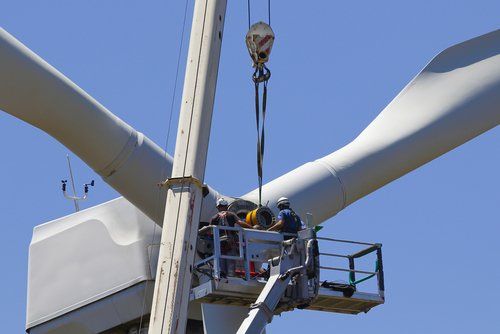 A group of men are working on a large wind turbine