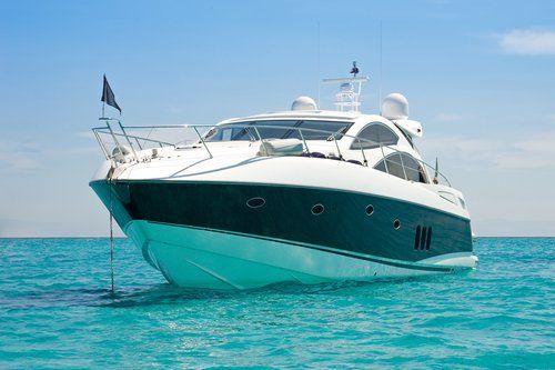 A large yacht is floating on top of a turquoise ocean.