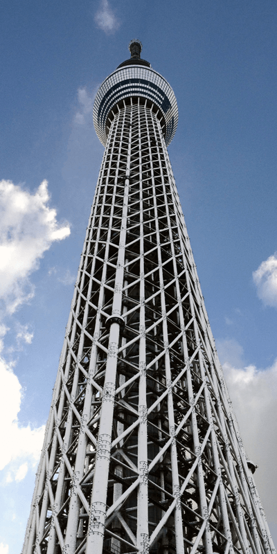 A very tall tower against a blue sky with clouds.