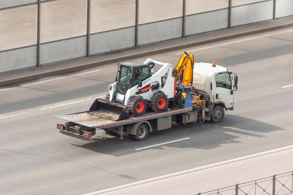 A Tow Truck Is Carrying A Bulldozer On The Back Of It — Gympie/Childers Towing Pty Ltd in Kybong, QLD