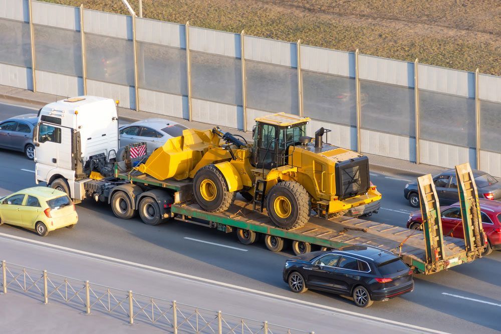 A Truck Is Carrying A Bulldozer On A Trailer On A Highway — Gympie/Childers Towing Pty Ltd in Maryborough, QLD