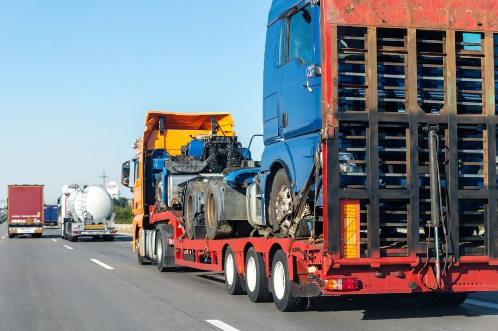A Row Of Semi Trucks Are Driving Down A Highway — Gympie/Childers Towing Pty Ltd in Bundaberg, QLD