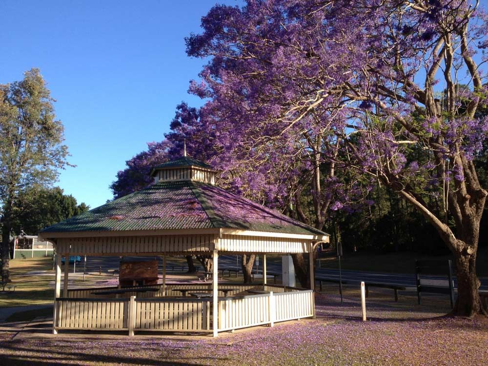 A Gazebo Surrounded By Purple Flowers And Trees — Gympie/Childers Towing Pty Ltd in Gympie, QLD