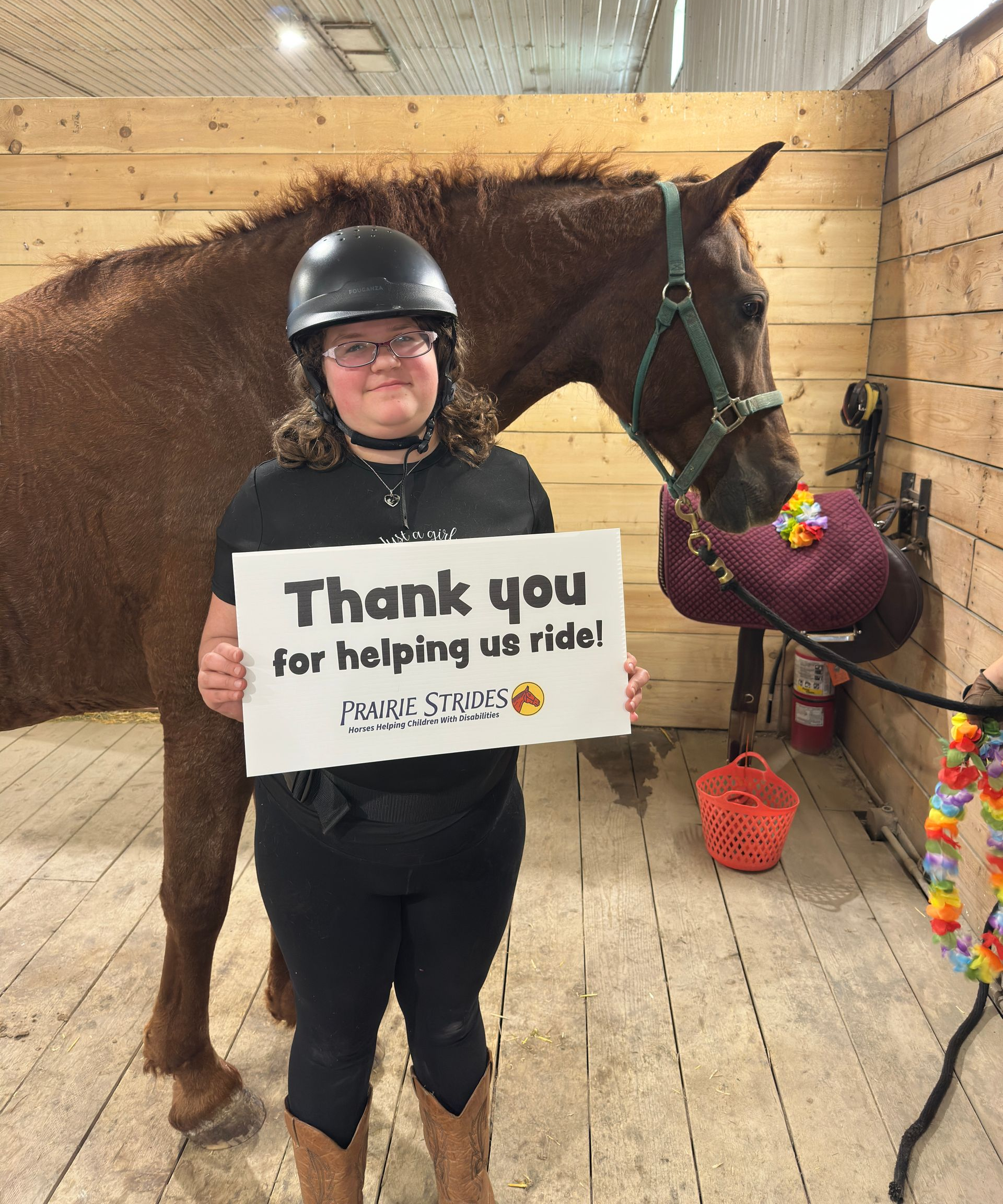 Person in riding helmet holding sign saying