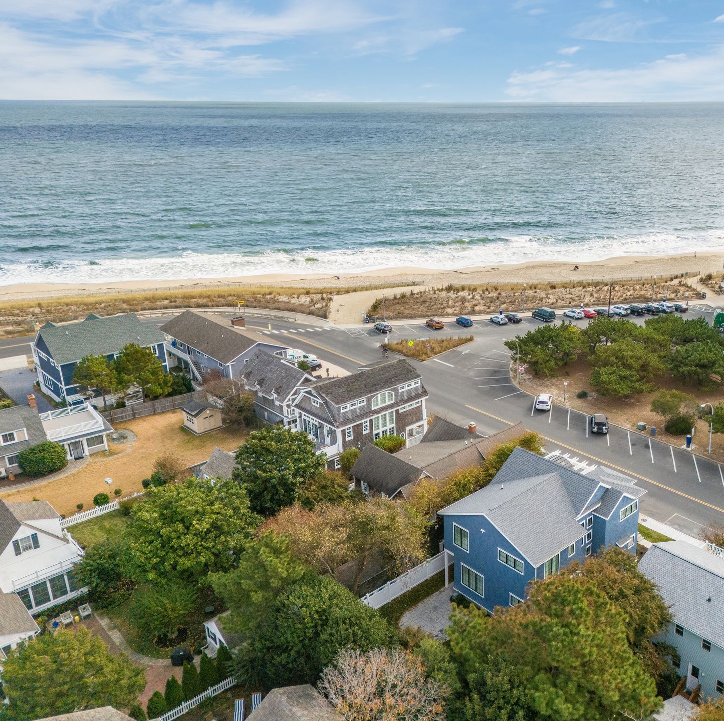 Aerial view of beach houses near the ocean. Blue water and sky.
