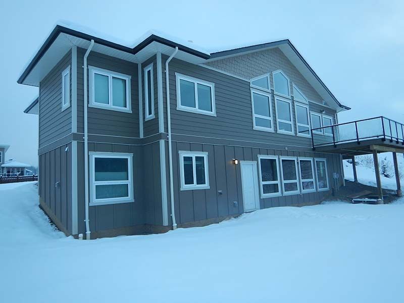 A large house with a lot of windows is covered in snow.