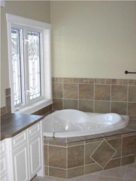 A bathtub in a bathroom next to a window