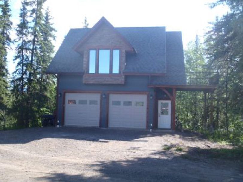 A house with two garage doors and a large window