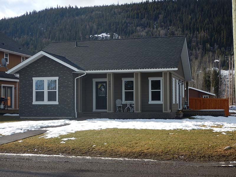 A house with a porch and a mountain in the background