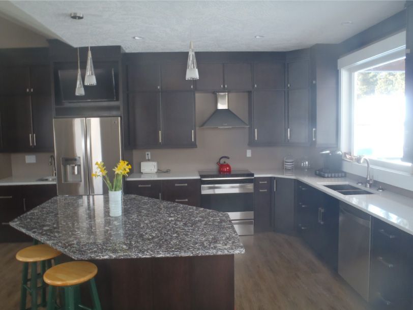 A kitchen with granite counter tops and stainless steel appliances
