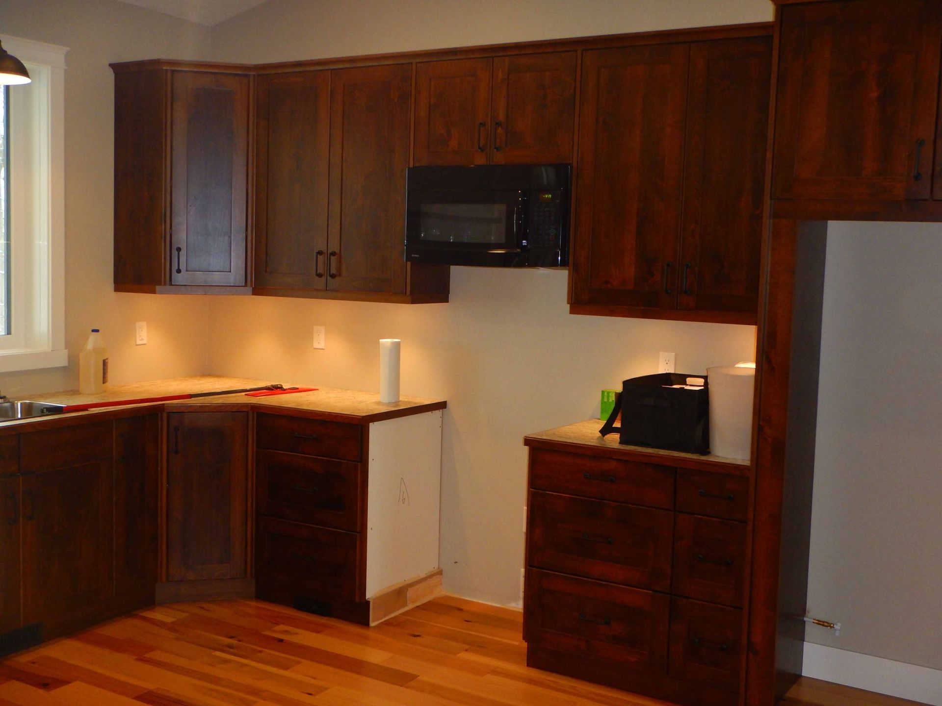 A kitchen with wooden cabinets and a microwave