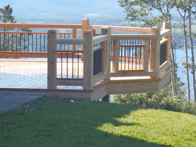 A wooden deck with a railing overlooking a body of water