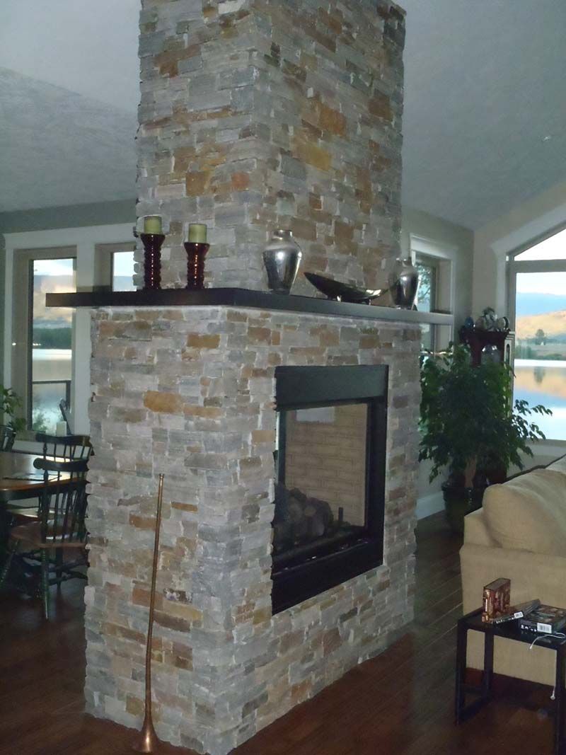 A living room with a stone fireplace and a couch