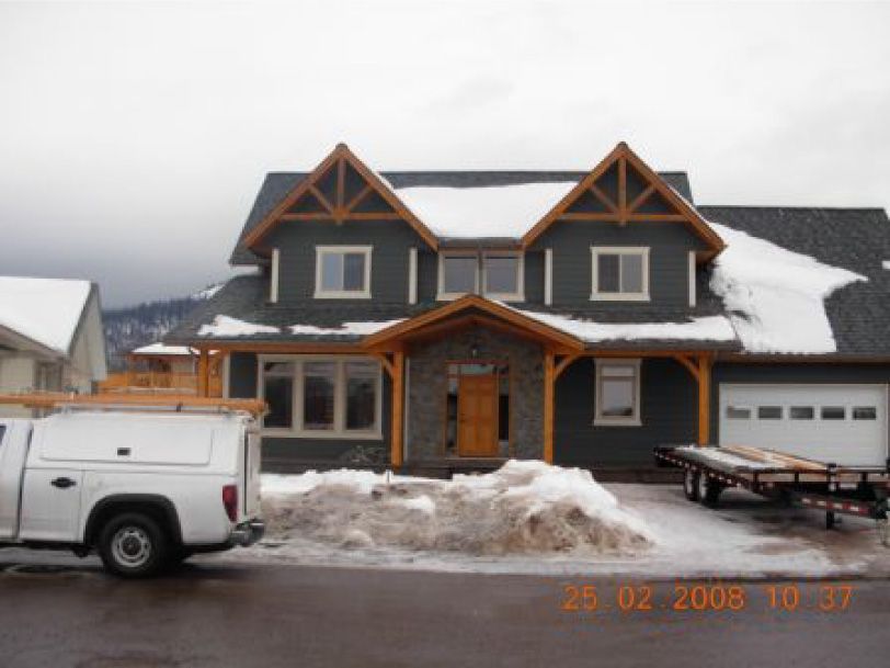 A truck is parked in front of a house with snow on the ground