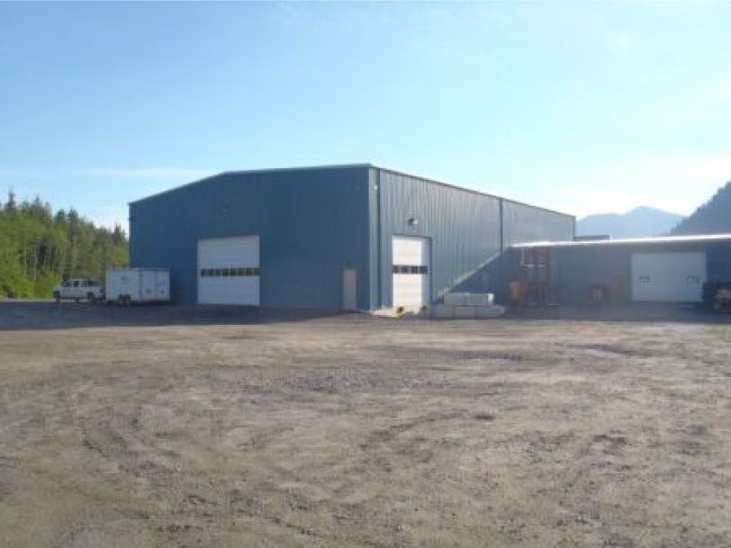 A large building with a lot of doors and a truck parked in front of it