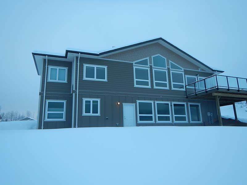 A large house with a lot of windows is covered in snow