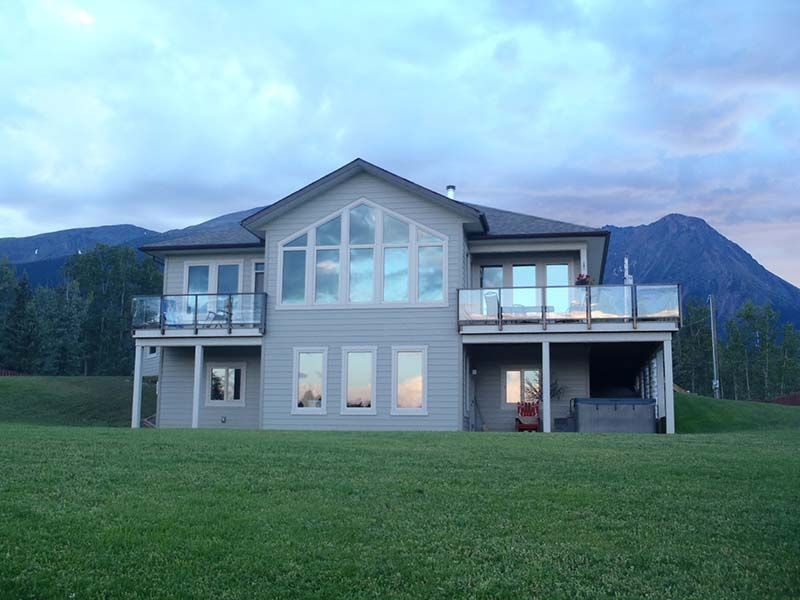 A large house with a lot of windows and mountains in the background