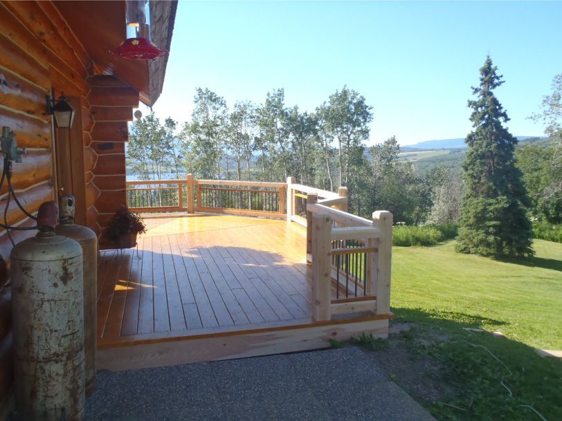 A large wooden deck with a gas cylinder in front of it