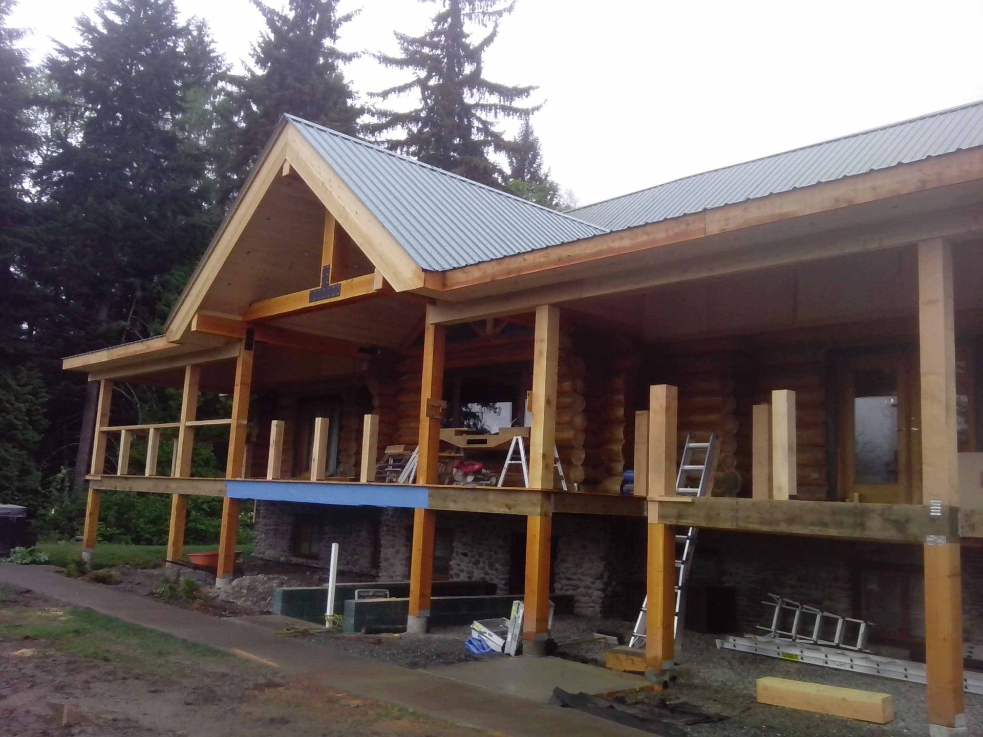 A large log cabin is being built with a metal roof